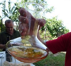 Golden natural wine being poured from a bowl during a tasting